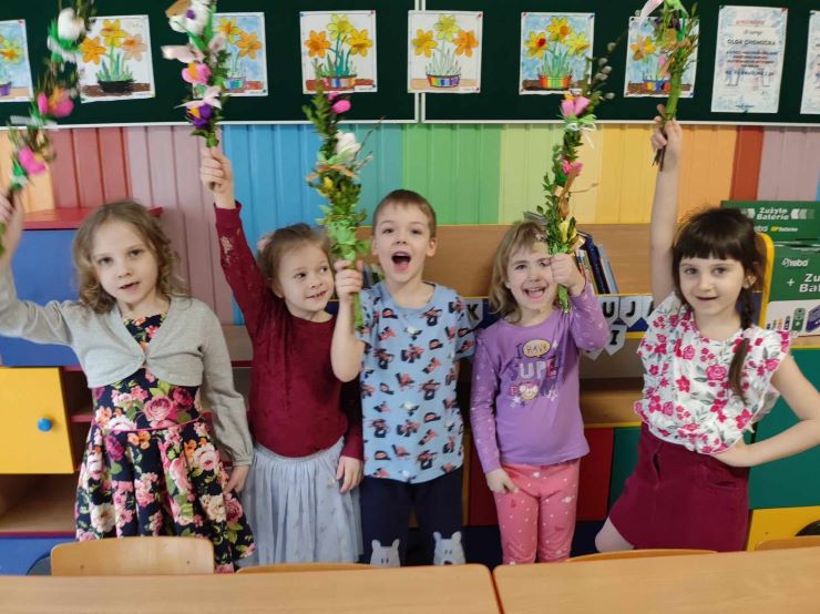 Grupa dzieci prezentuje wykonane własnoręcznie palmy wielkanocne 